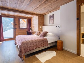 Cozy bedroom with a large bed, bedside table, and wooden nightstand.