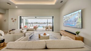 Un salón amplio con un televisor de pantalla plana grande que muestra 'CoralVilla Villa & Boat Rental'.