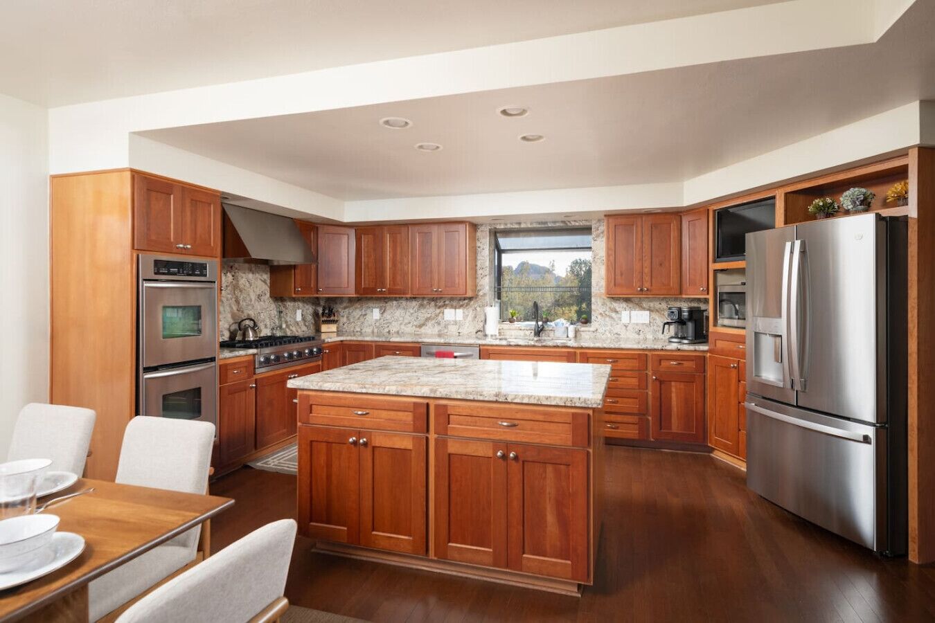 A modern kitchen with wooden cabinets, stainless steel appliances, and a large island.