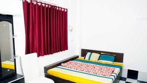 Una habitación de hotel con una cama, una silla, un espejo y suelo a cuadros.