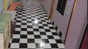 Un pasillo con piso a cuadros, puertas y un ventilador de techo.