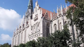 Un edificio histórico con arquitectura intrincada, que incluye una aguja alta y detallada labor en piedra.