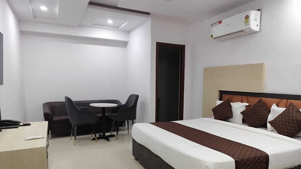 Ein Hotelzimmer mit Bett, Schreibtisch, Stuhl und kleinem Tisch.