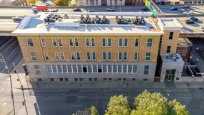 A multi-story building with a flat roof, large windows, and a visible parking lot.