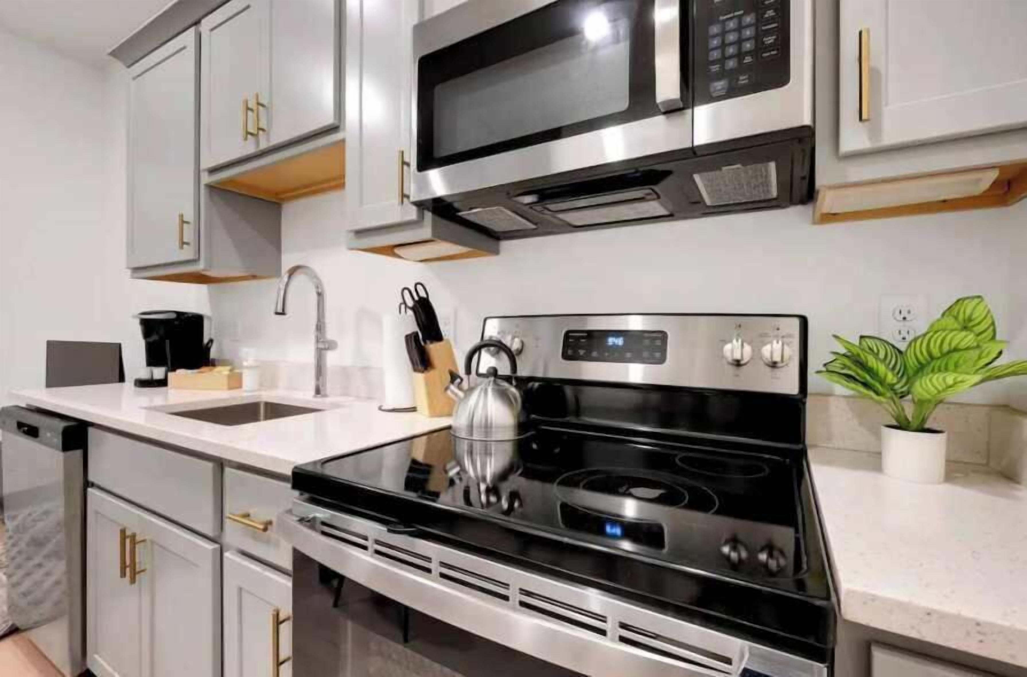 A modern kitchen with stainless steel appliances, a built-in oven, and a microwave above the stove.