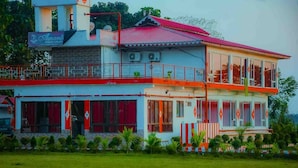 A two-story building with a red roof, large windows, and a balcony. - Amantran Hotel & Resort (Alipurduar)