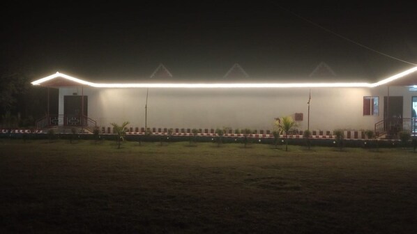 A building with a flat roof and a long, illuminated edge. - Amantran Hotel & Resort (Alipurduar)