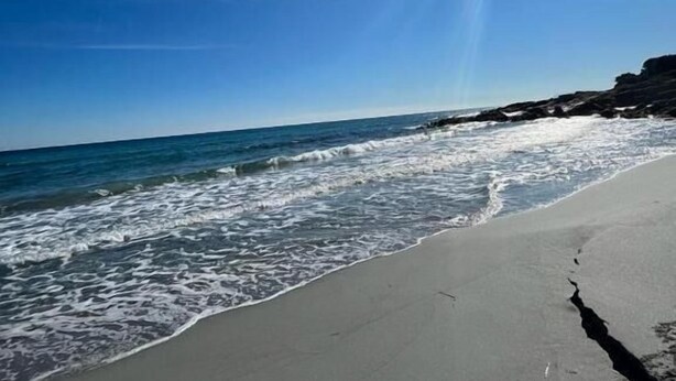 A beach with clear skies and sunlight reflecting off the water. - Casa Donatella (Orosei)