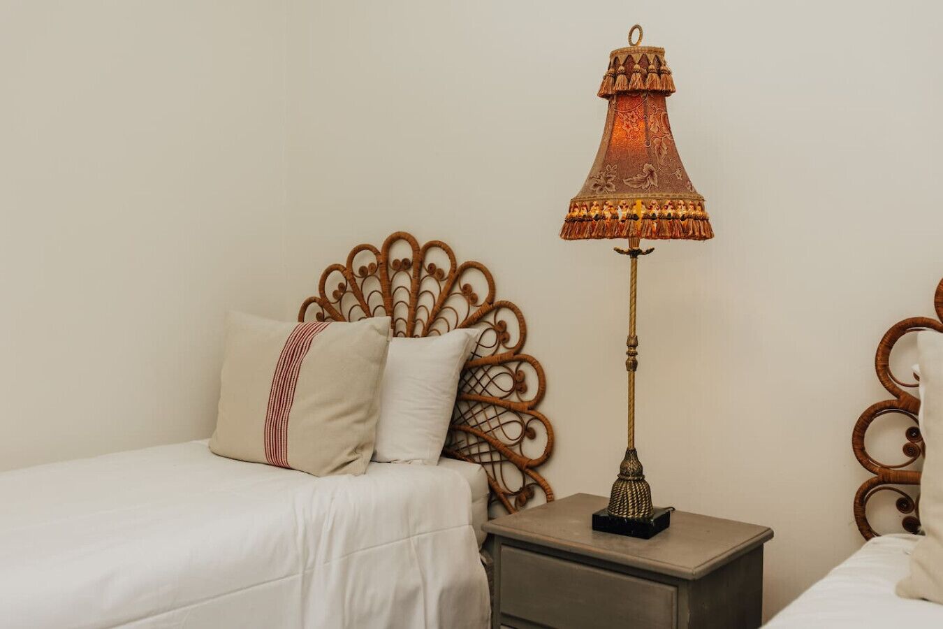 Una camera da letto con un letto, un comodino, una lampada decorativa e una testiera a parete.