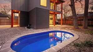 A modern two-story house with a swimming pool in the backyard.