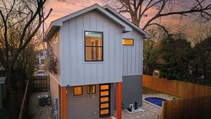 A two-story house with a garage, a swimming pool, and a fenced backyard.