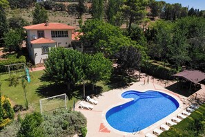 A swimming pool with a heart-shaped design, surrounded by lounge chairs and a small pavilion. - Las Melias (Ciudad Real)