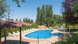 A swimming pool with lounge chairs and a pergola. - Las Melias (Ciudad Real)