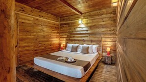 A wooden cabin room with a bed, bedside lamps, and a tray with cups and a book. - Alaya Stays Suro Woodbine Chalet Cottage (Kandaghat)