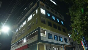 A multi-story building with balconies and windows, featuring a sign that says "Sale." - Hiraa inn Studio Apartments (Kurnool)