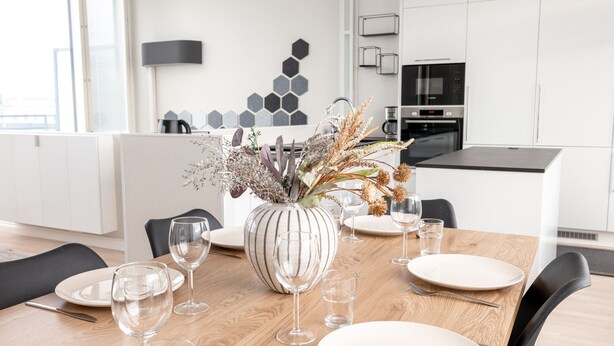 Una cocina moderna con armarios blancos, microondas y cafetera.