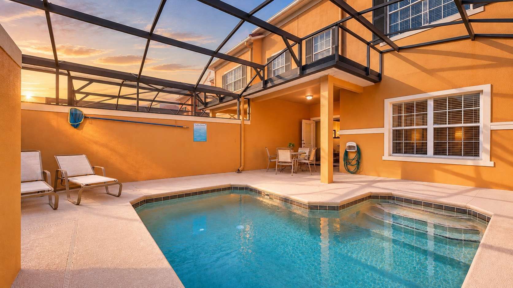 A swimming pool with a glass ceiling and a view of the sunset.