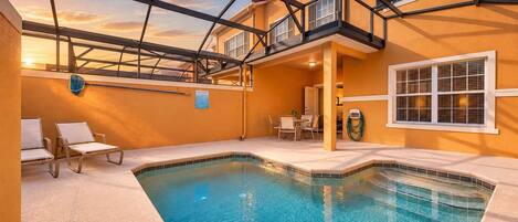 A swimming pool with a glass ceiling and a view of the sunset.