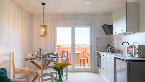 Una cocina moderna con comedor, un amplio ventanal y vistas al exterior.