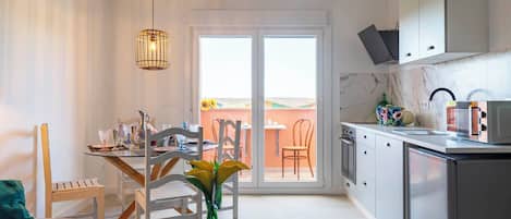 Superior studio, terras | Privékeuken | Een koelkast, een magnetron, een kookplaat, kookgerei, borden en bestek