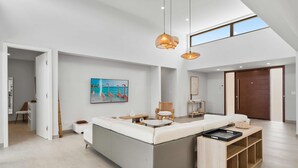 A modern living room with a large L-shaped sofa, a wooden coffee table, and a dining area with a small table and chairs. - Safir 40 (Noord)