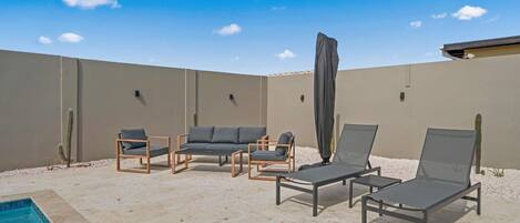 A poolside area with lounge chairs, a small pool, and cacti.
