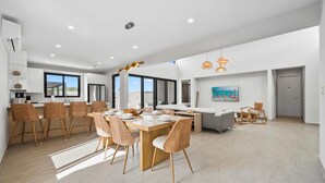 A spacious kitchen with modern appliances, a dining area with wicker chairs, and a large window providing natural light. - Safir 40 (Noord)