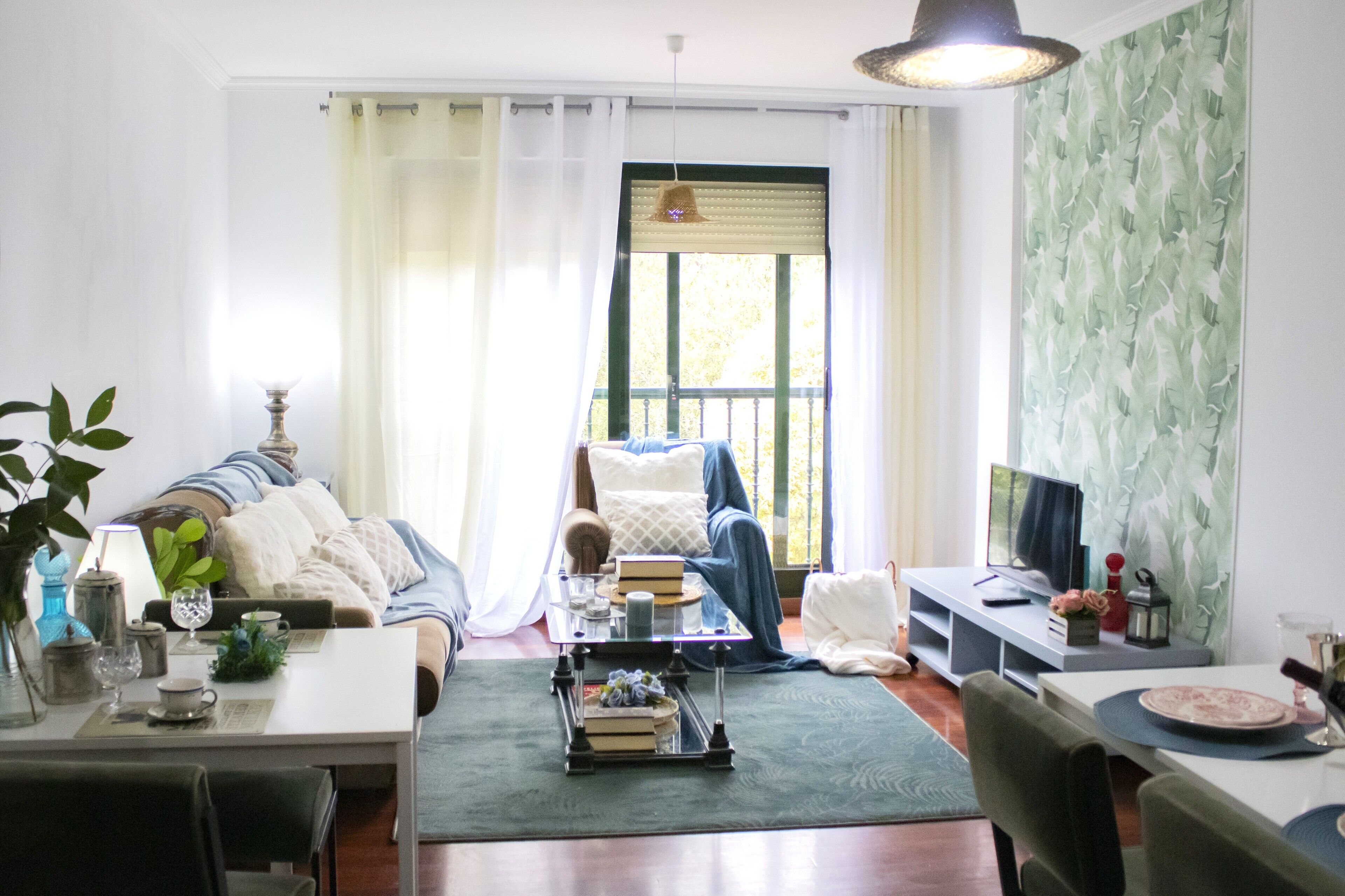Una sala de estar con sofá, mesa de centro y televisor.