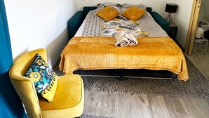 A bedroom with a bed, a chair, a bedside table, and a wardrobe. - La Maison des Crêtes - Studio with view of the Vercors mountains (Parnans)