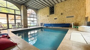 An indoor swimming pool with stone walls and a covered ceiling. - Beautiful stone barn with year-round heated pool<br>Magnificent setting in the heart of the Perche region (Belforêt-en-Perche)
