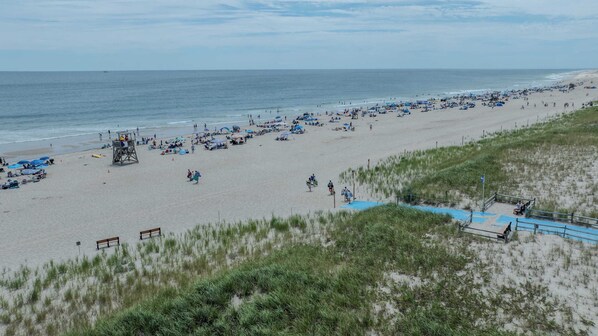 Een strand met veel parasols en mensen.