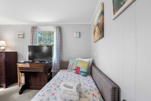 A bedroom with a bed, a desk, a television, and a window with curtains. - Studio, Walk to Nauset Beach! (Orleans)
