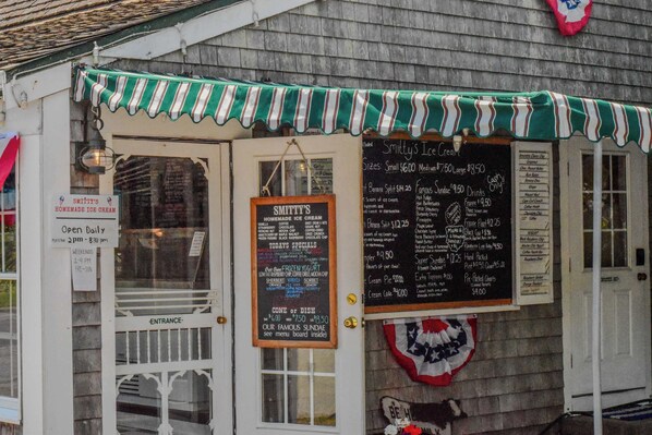 A storefront with a green and white striped awning, a menu board, and a sign indicating the business is open daily. - Studio perfect for 3, Walk to Nauset Beach! (Orleans)