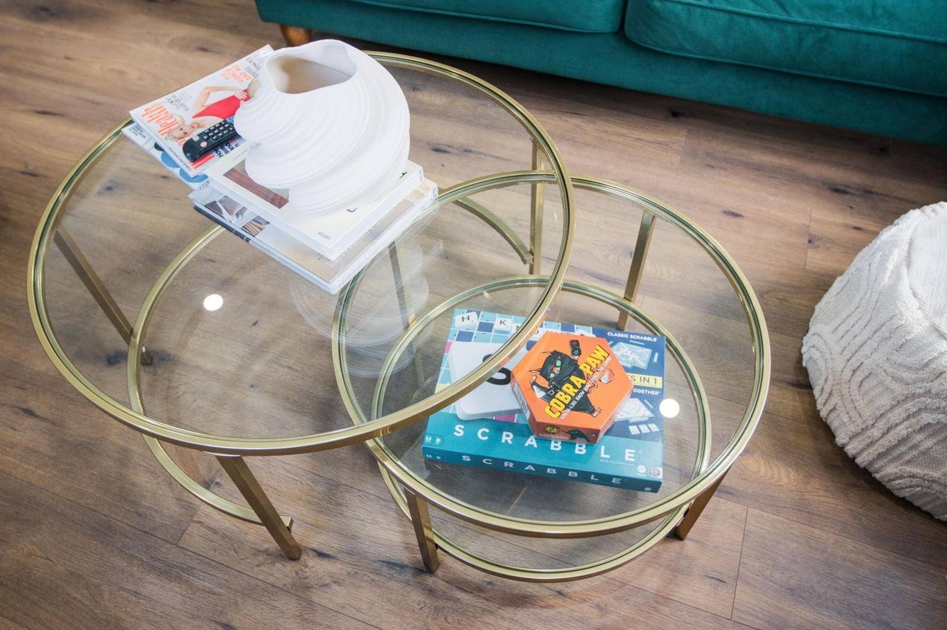 A glass-top coffee table with a magazine and a board game.
