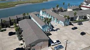 A coastal property with multiple buildings, a parking area, and a view of the sea.