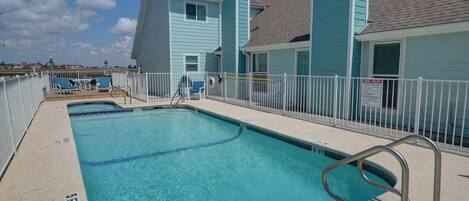 A swimming pool with a 5 FT depth marker, a pool rules sign, and a no diving sign.