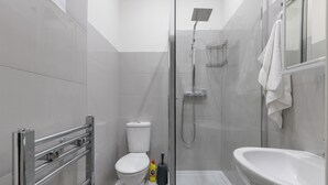 Un baño moderno con inodoro, ducha y lavamanos.