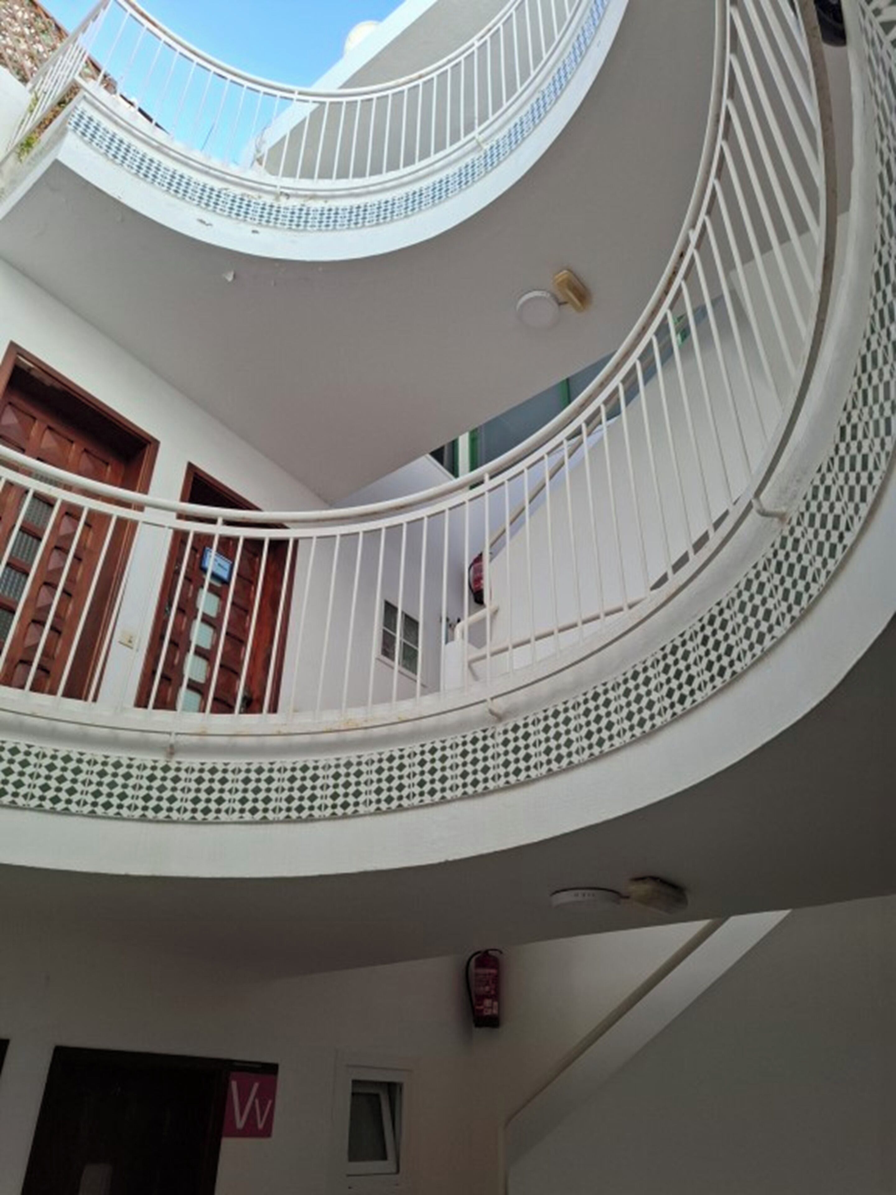 A multi-level interior with white railings and a circular staircase.
