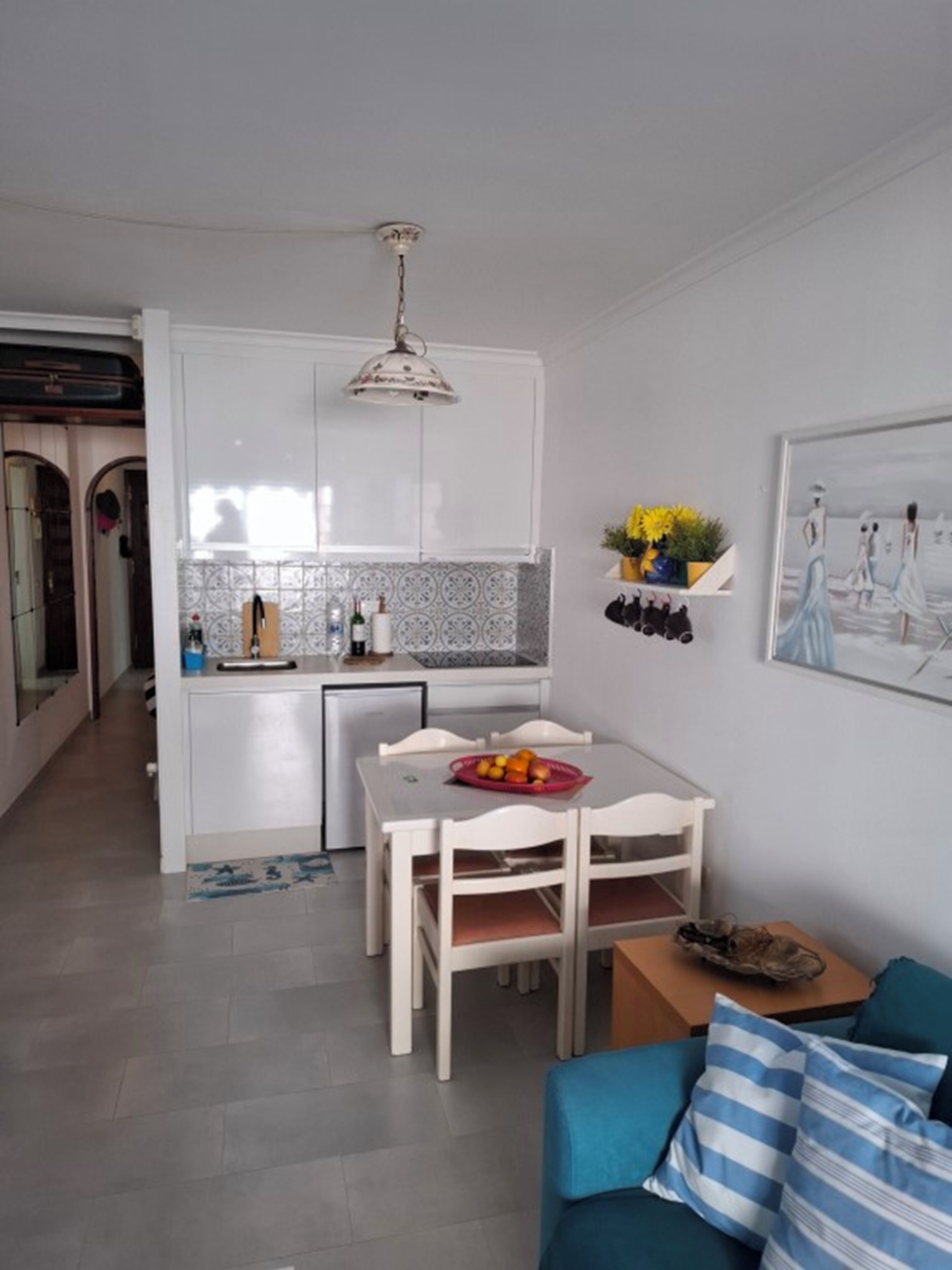 Um espaço compacto com cozinha compacta, área de refeições e um sofá.