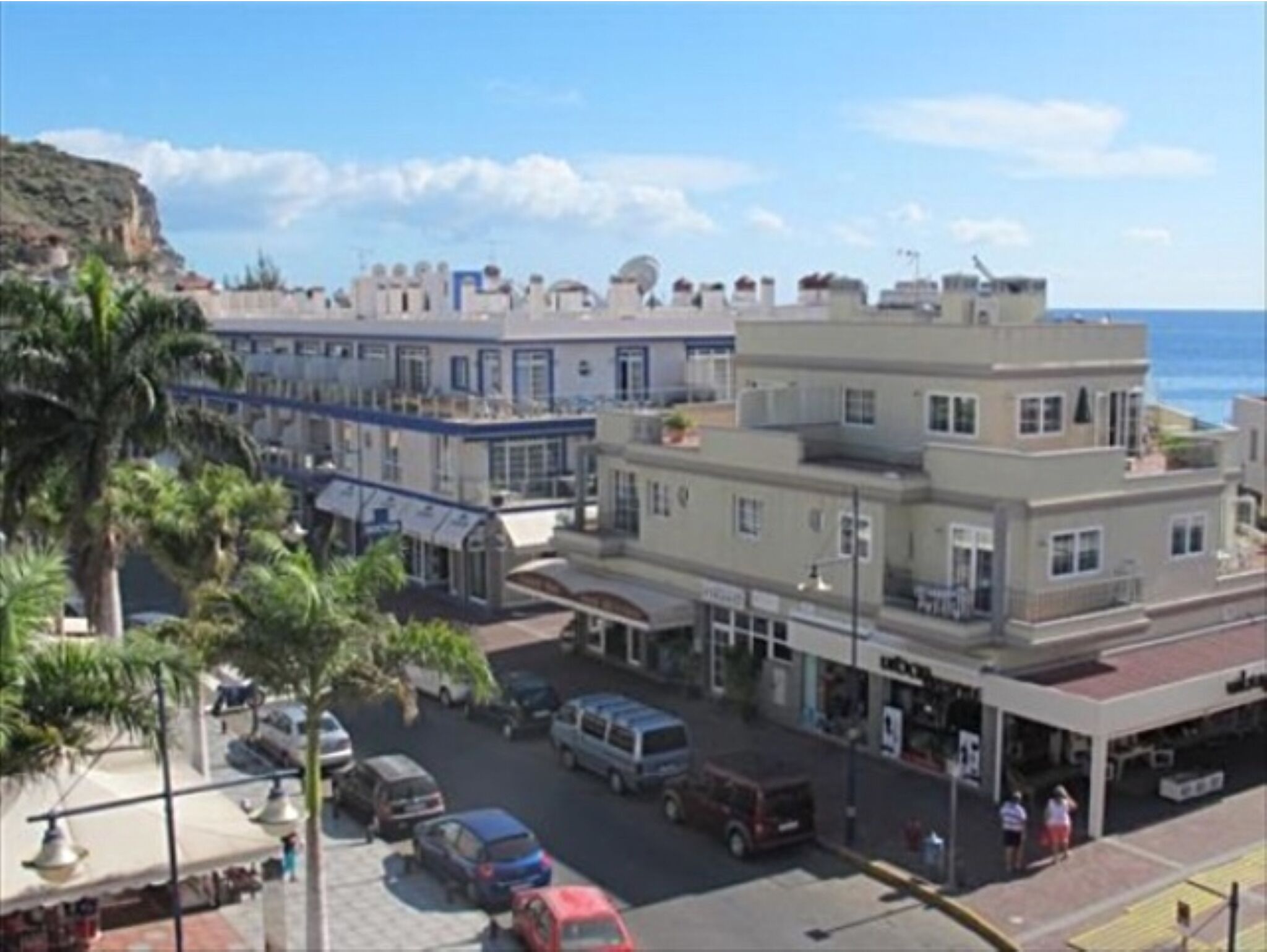 A coastal building with a ground floor shop and upper residential units.