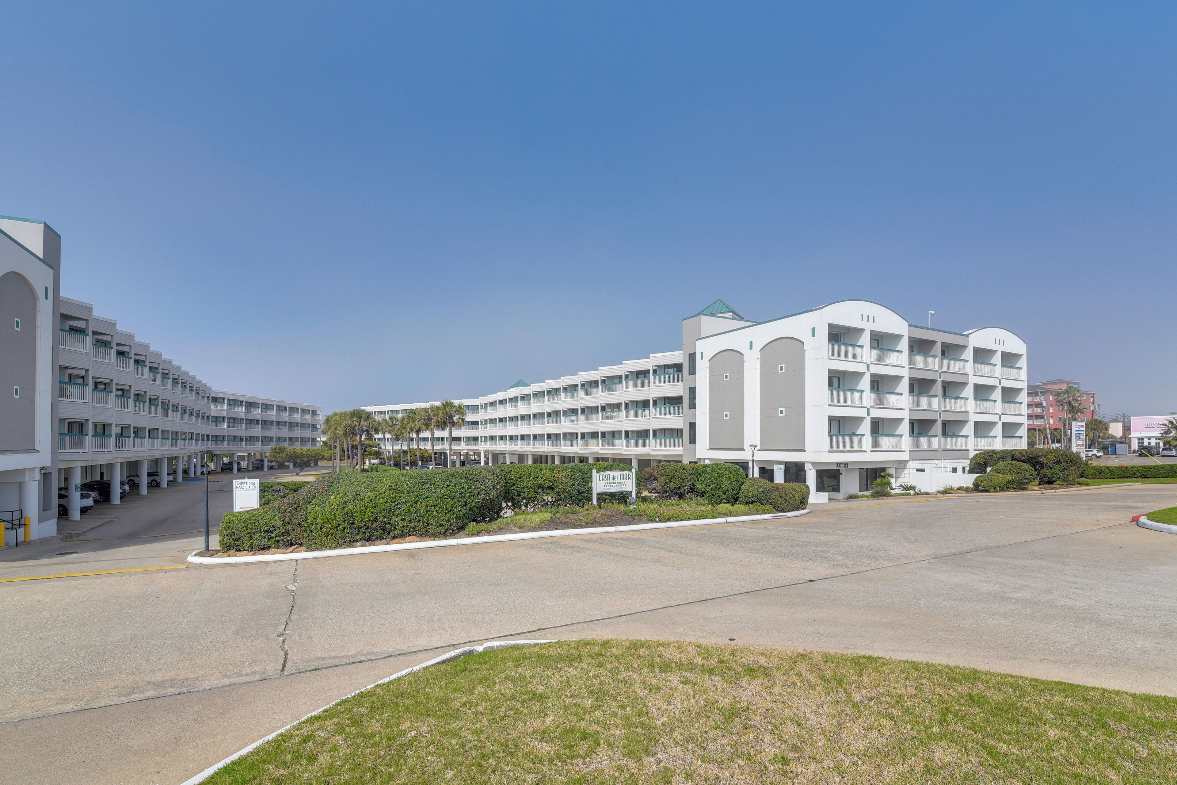 Hotel com vários andares, pátio central, estacionamento e placa indicando local de testes para COVID-19.