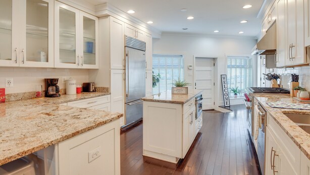 A modern kitchen with white cabinetry, granite countertops, and stainless steel appliances. - Rooftop Patio w/ View: Baltimore Retreat (Baltimore)