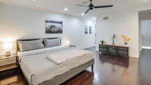 A bedroom with a large bed, a ceiling fan, and a nightstand with a lamp. - Rooftop Patio w/ View: Baltimore Retreat (Baltimore)