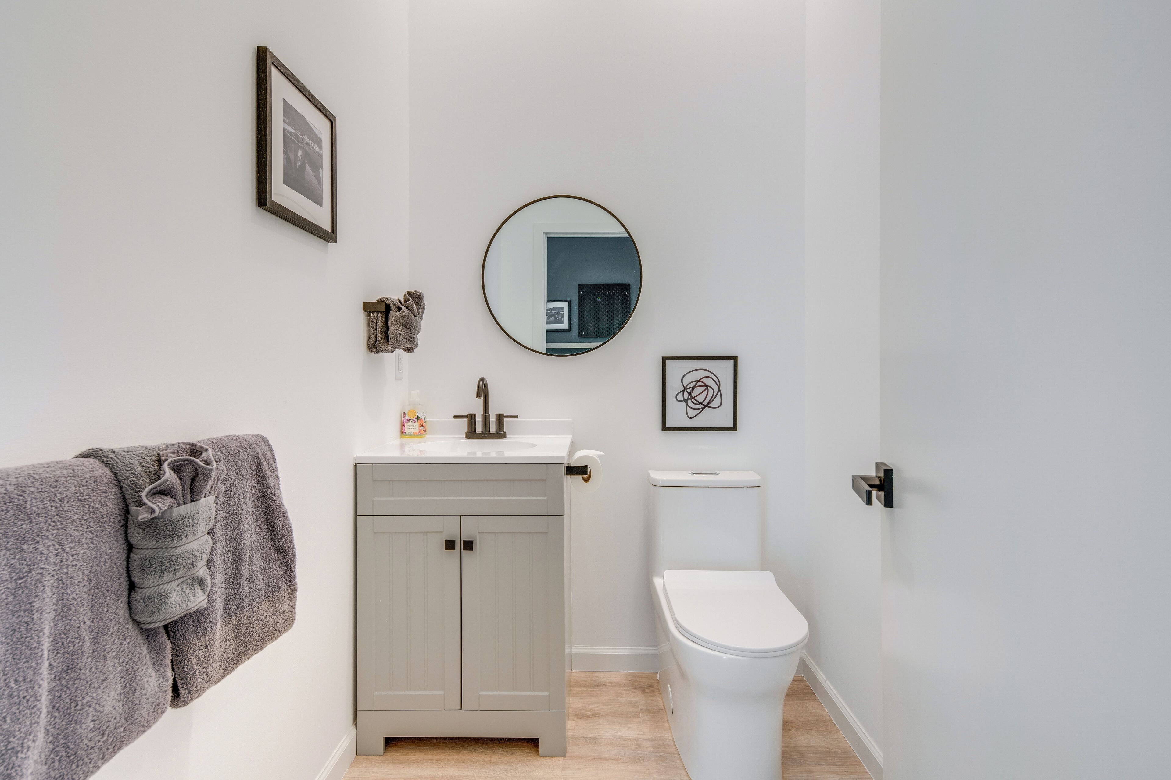 Une salle de bain avec des toilettes, un lavabo et un miroir.