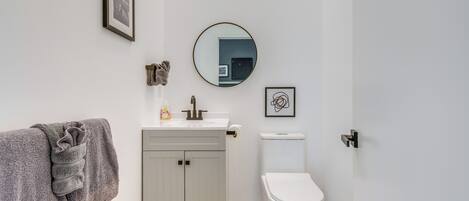 Une salle de bain avec des toilettes, un lavabo et un miroir.