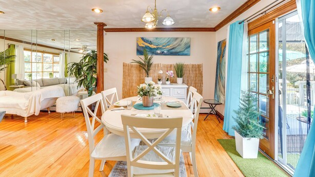 A dining area with a round table, white chairs, and a ceiling fan. - Creekside Catskills Retreat: Deck, Bbq, & Firepit (Parksville)