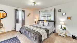 A bedroom with a bed, bedside tables, a mirror, curtains, a window, and a wall clock. - Creekside Catskills Retreat: Deck, Bbq, & Firepit (Parksville)