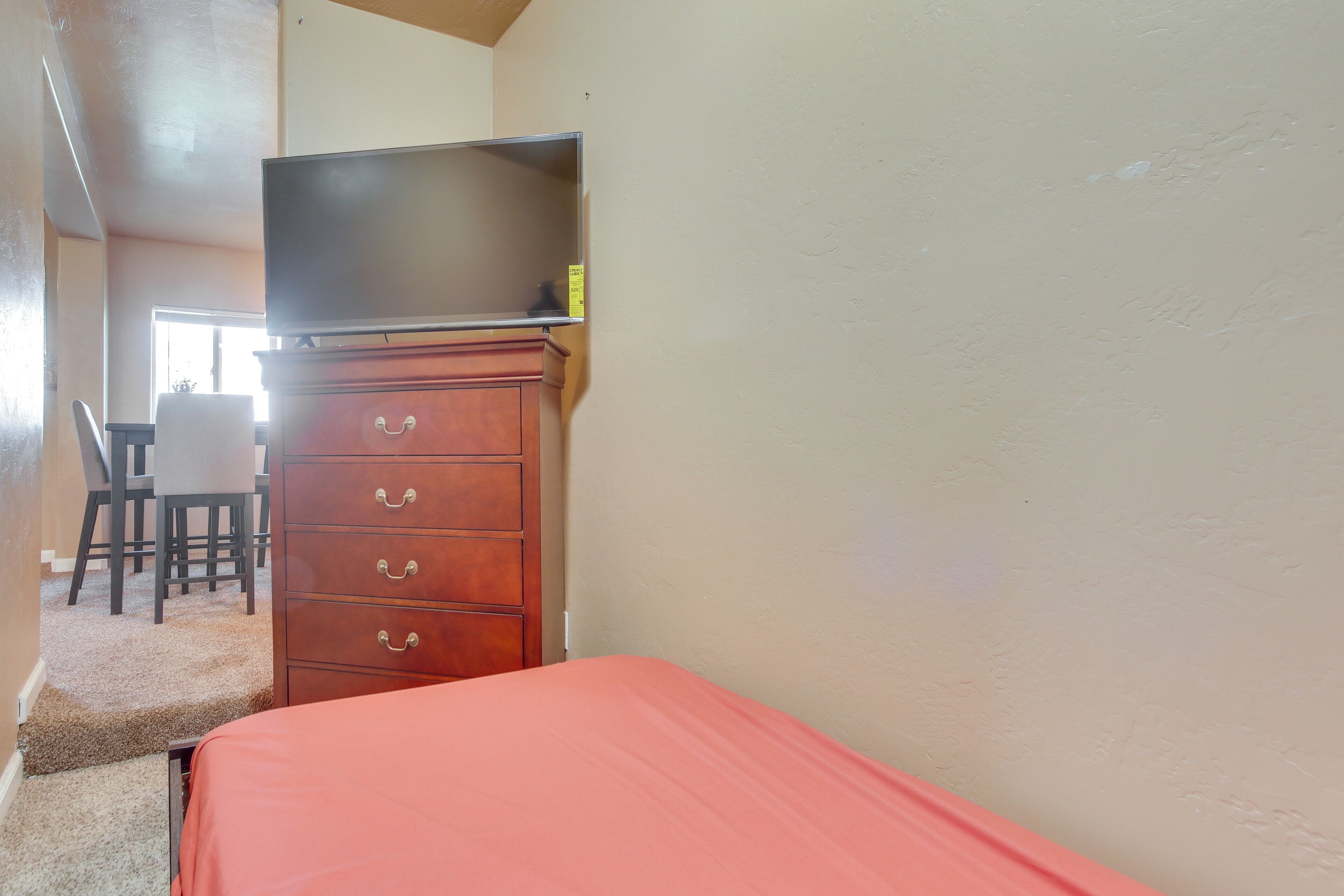 Un dormitorio con cama, cómoda y televisor encima de la cómoda.