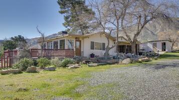 A single-story house with a covered porch, a stone foundation, and a small attached garage.