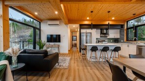 Una cocina moderna con techo de madera, ventanas amplias y una barra.